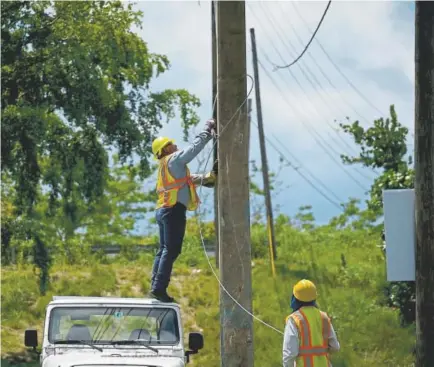  ??  ?? Workers removed damaged cables from a post in San German, Puerto Rico, on Wednesday.