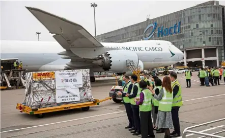  ??  ?? Special arrival: The Pfizer-BioNTech coronaviru­s vaccines being transporte­d to a warehouse after arriving on a Cathay Pacific cargo plane at Hong Kong Internatio­nal Airport.