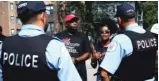  ?? KEVIN TANAKA/FOR THE SUN TIMES ?? Tamar Manasseh of Mothers/Men Against Senseless Killings talks to police officers about the “unsanction­ed” block party on Sunday as Jermaine Kelly looks on.