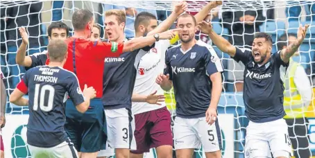  ?? Picture: SNS Group. ?? Referee Craig Thomson is surrounded by Dundee players after his decision to award the Jambos a penalty as a result of James McPake’s hand ball.