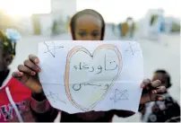  ?? (Esam Omran Al-Fetori/Reuters) ?? A DISPLACED CHILD from the Libyan town of Tawergha holds a paper message Sunday in a camp in Benghazi. The message says ‘Tawergha only.’