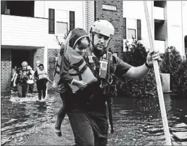  ?? ETHAN HYMAN/RALEIGH NEWS & OBSERVER ?? Firefighte­rs in Spring Lake, N.C., rescue residents at an apartment building on Monday.