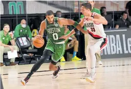  ??  ?? FIGURA. Jayson Tatum, de Boston Celtics, enfrenta a Zach Collins, de Portland Trail Blazers, en el duelo de ayer en Disney World.