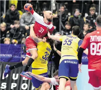  ?? AP ?? Beim Handball wird zugepackt: Hier erfährt dies der Russe Timur Dibirow (l.) im Spiel gegen Schweden.