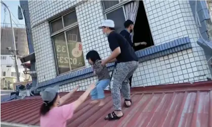  ?? Photograph: Anonymous/AP ?? Image taken from video footage run by TVBS shows people rescuing a child from a partially collapsed building in Hualien, eastern Taiwan.