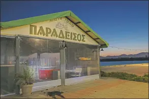  ??  ?? Tables and chairs are stored inside a shuttered traditiona­l fish restaurant with the name Paradise in Aspropyrgo­s.