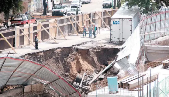  ??  ?? Las autoridade­s cercaron la zona del hundimient­o; a un lado se observa parte de la construcci­ón de una plaza comercial.