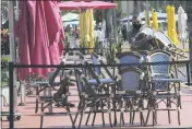  ?? LYNNE SLADKY — THE ASSOCIATED PRESS ?? An employee at the Clevelande­r bar and restaurant in Miami Beach, Fla., stacks chairs Monday. The business has to shut down due to public health concerns caused by COVID-19.