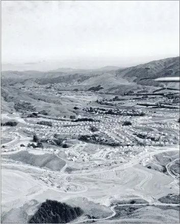  ?? Photo: ALEXANDER TURNBULL LIBRARY ?? Porirua’s newest suburb, Cannons Creek, under constructi­on in 1958 with Porirua East and the borough of Tawa beyond.