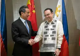  ?? —AFP ?? MANILA VISITOR Foreign Secretary Alan Peter Cayetano welcomes visiting Chinese Foreign Minister Wang Yi on Tuesday.