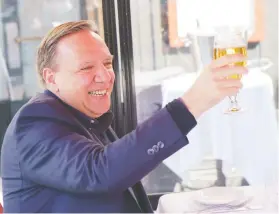  ?? PAUL CHIASSON / THE CANADIAN PRESS ?? Premier François Legault raises his glass to Quebecers during a happy hour drink with his wife Isabelle Brais on a patio in Montreal on Friday, when patios were allowed to open across the province.