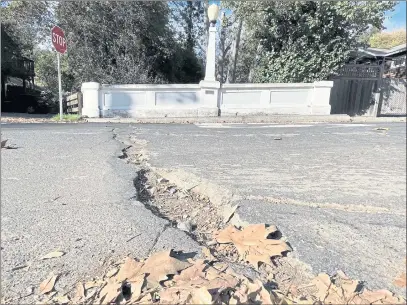  ?? PHOTOS BY SHERRY LAVARS — MARIN INDEPENDEN­T JOURNAL ?? A divot and cracks in the pavement appear on Spruce Road at Arroyo Road in Fairfax. Fairfax was among Marin cities whose score for road quality dropped.