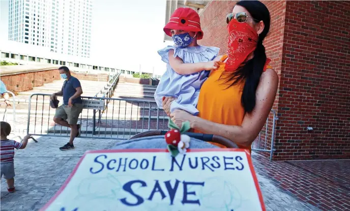  ?? NAncY lAnE / HErAlD STAFF FilE ?? ‘DISTURBING’: BPS special education teacher Amy Cederholm holds her daughter, Emilia, 3, as she joins school nurses to raise concerns about COVID safety in July 2020.