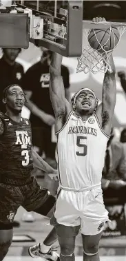  ?? Michael Woods / Associated Press ?? Moses Moody of Arkansas dunks in front of Texas A&M’s Quenton Jackson for two of his 28 points.