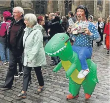  ?? Pictures: PA. ?? An armed police officer on duty on the Royal Mile and right, a performer does a bit of promotion.