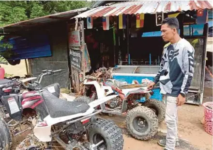  ?? (Foto Roselan Ab Malek/bh) ?? Mohd Zaimi melihat ATV miliknya yang rosak akibat banjir di kawasan Kampung Pulau Santap, Janda Baik, semalam.