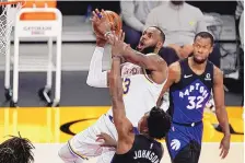  ?? MARK J. TERRILL/ASSOCIATED PRESS ?? Los Angeles’ LeBron James, center, shown shooting against Toronto on Sunday night, has voiced his opposition to the play-in tournament the league is running.