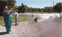  ?? Mike Snyder / Houston Chronicle ?? Greg Watson photograph­s a low-water crossing that maroons residents in Fort Bend County’s Tierra Grande subdivisio­n.