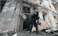  ?? ANDRII MARIENKO — THE ASSOCIATED PRESS ?? A woman walks out from a residentia­l building which was hit by a Russian rocket, in the city center of Kharkiv, Ukraine, Sunday.