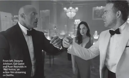  ?? FRANK MASI TNS ?? From left, Dwayne Johnson, Gal Gadot and Ryan Reynolds in ‘Red Notice,’ an action film streaming on Netflix.