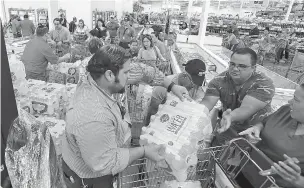  ??  ?? Miami residents stand in a long line to purchase water Tuesday at BJ Wholesale in preparatio­n for Hurricane Irma. With images of Harvey’s wrath in Texas still fresh and 25-year-old memories of Hurricane Andrew’s destructio­n, warnings that Hurricane...