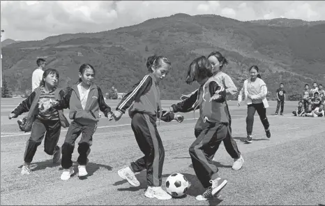  ?? PHOTOS BY FANG AIQING / CHINA DAILY ?? Above: Girls play soccer at Tiedaobing Hope School in Puge county, Liangshan Yi autonomous prefecture, Sichuan province.
Left: Junior middle school students of Wenchang middle school in Yuexi county, Liangshan, study chemistry in their classroom.
Below left: Boys of Wenchang middle school play basketball on the court at their new campus.
Below right: Children in Zhongba village, Xide county, Liangshan, play on the swings and the slide for the first time in the village’s kindergart­en.