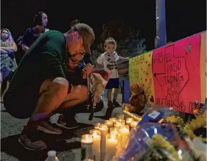  ?? ANDRES LEIGHTON/AP ?? Rene Aguilar and Jackie Flores pray at a makeshift memorial for the victims of Saturday’s mass shooting at a shopping complex in El Paso.