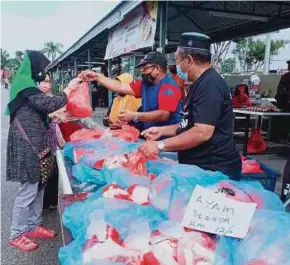  ?? (Foto Amir Mamat/bh) ?? Ahli Jawatankua­sa Masjid Jamek Ar-rahman menjual ayam segar di Pasar Sunday Kampung Pulai, Jasin, semalam.