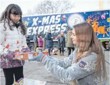  ?? FOTO: DPA ?? In Osnabrück verteilt die Truckerin und Spediteuri­n Janina Martig mit ihrem X-Mas-Express zu Weihnachte­n Spielzeug-Geschenke an bedürftige Kinder.