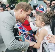  ?? BEN BIRCHALL/PA VIA THE ASSOCIATED PRESS ?? Prince Harry greets a young well-wisher during a walkabout with Prince William outside Windsor Castle, in Windsor, England on Friday.