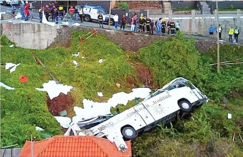  ??  ?? A video grab obtained from drone footage shows the wreckage of a tourist bus that crashed in Canico, on the Portuguese island of Madeira. — AFP photos