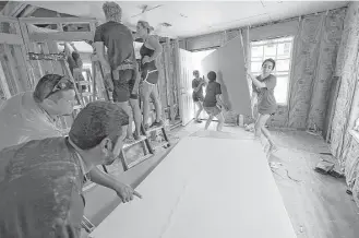  ?? Jerry Lara photos / San Antonio Express-News ?? Volunteers for Proyecto Azteca build a house for a Hidalgo County colonia. The nonprofit’s leaders say the need for housing far outstrips what it and other organizati­ons can provide.