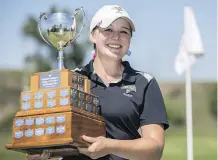  ?? CRYSTAL SCHICK/ CALGARY HERALD ?? Sydney MacDonald hoists the trophy after winning the Calgary Ladies Golf Associatio­n Amateur championsh­ip.