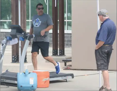  ?? JOE FRIES/Penticton Herald ?? Penticton Vees coach Fred Harbinson chats with a fan Wednesday morning while maintainin­g a brisk clip on a treadmill set up outside the South Okanagan Events Centre. Harbinson, also the club’s general manager and president, pledged to stay on the treadmill until the team sold 30 season tickets for the upcoming season. Ticket packages start at $10 per game and payments plans are available.