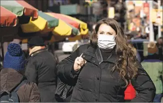  ?? Mark Lennihan Associated Press ?? SURGICAL MASKS, like one worn Thursday in New York, are being donned as protection against the coronaviru­s. Only six cases of the virus had been reported in the U.S. as of Thursday.