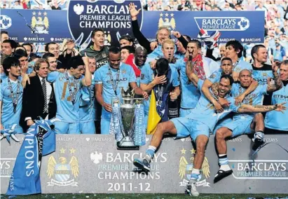  ?? Picture: GETTY IMAGES ?? BRAGGING RIGHTS: The Manchester City players and management celebrate with the trophy they won after the English Premier League match against Queens Park Rangers at the Etihad Stadium on Sunday. City can look back over a ‘crazy finish to a crazy...