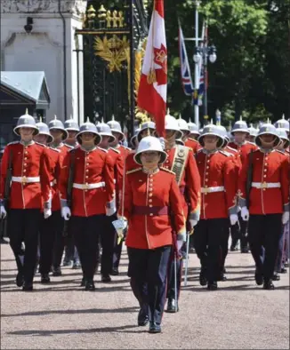  ?? JOHN STILLWELL, GETTY IMAGES ?? Canadian Megan Couto, centre, makes history by becoming the first female Captain of the Queen’s Guard as she takes part in the Changing the Guard ceremony at Buckingham Palace on Monday.