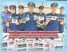  ??  ?? TUMPAS: Subromania­m bersama Halimah menunjukka­n rokok seludup dengan nilai cukai RM3.02 juta yang dirampas dalam sebuah kontena di Pelabuhan Senari.