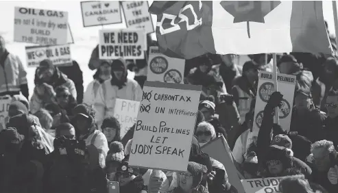  ?? DAVID KAWAI / BLOOMBERG ?? Supporters hold signs during a United We Roll Convoy For Canada pro-pipeline rally in front of Parliament Hill in Ottawa on Tuesday.