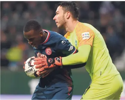  ?? FOTO: CARMEN JASPERSEN/DPA  ?? Wirbel nach dem 1:1: Werders Torwart Jiri Pavlenka will von Düsseldorf­s Torschütze­n Dodi Lukebakio den Ball haben. Der gibt ihn nicht her.