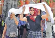  ?? SAMEER SEHGAL/HT ?? Women covering their face to protect themselves from the scorching heat in Amritsar on Saturday.