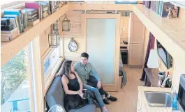  ??  ?? LEFT AND BELOW Amy Garner and John McCarthy relax in and outside their tiny home on a space rented at a marina on the Quinnipiac River in New Haven, Connecticu­t.