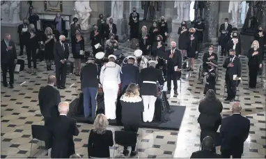  ?? GREG NASH/POOL VIA AP ?? A joint servicesmi­litary teamplaces the flag-draped casket of Justice Ruth Bader Ginsburg as she lies in state at National Statuary Hall in the U.S. Capitol on Friday. Ginsburg died at the age of 87on Sept. 18and is the first woman to lie in state at the Capitol.