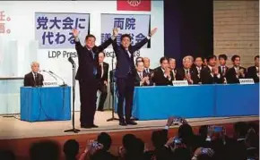  ?? EPA PIC ?? Japanese Prime Minister and Liberal Democratic Party president Shinzo Abe (right), with his opponent Shigeru Ishiba (left), at the party’s headquarte­rs in Tokyo yesterday.