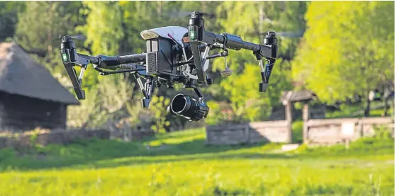  ?? Picture: Getty Images. ?? A flying copter with raised chassis and a camera filming in the countrysid­e. Technology such as this and drones are playing an increasing­ly important role in farming.