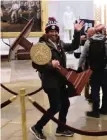  ?? WIN MCNAMEE Getty Images ?? Adam Christian Johnson, 36, of Parrish, carries the lectern bearing the seal of the speaker of the House during Wednesday’s Capitol incursion by a pro-Trump mob.