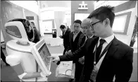  ?? PROVIDED TO CHINA DAILY ?? Visitors contact with a bank’s robot at an exhibition in Beijing. Financial institutio­ns are required to remind investors of the flaws and risks associated with algorithm-based robo-advisory models.