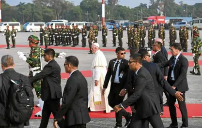  ?? AFP ?? Pope Francis is escorted by a phalanx of security men on his arrival in Dhaka on Wednesday.—