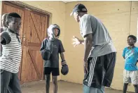  ??  ?? Right, boxing trainer Zamikhaya Maxapana givesLamkh­elo Manikonkwa­na some pointers while Lutho Gamnca and Kwenzekile Mrobo look on. Fellow trainees form a ring by holding hands and encircling the fighters.