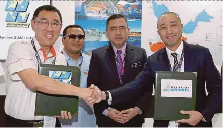  ??  ?? Malaysia Airports Holdings Bhd group chief executive officer Raja Azmi Raja Nazuddin (left) exchanging a memorandum of understand­ing with Boustead Projek Ltd deputy chairman Wong Yu Wei at the Langkawi Internatio­nal Maritime and Aerospace exhibition 2019 in Langkawi yesterday. With them are Transport Minister Anthony Loke (second from right) and Selangor Menteri Besar Amirudin Shari.